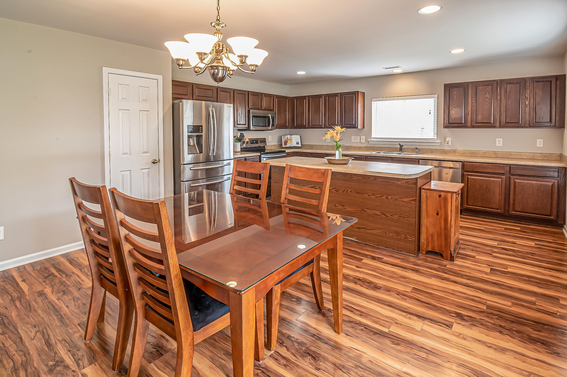 A modern kitchen and dining area featuring wooden floors and cabinetry, perfect for home design inspiration in Austin, TX