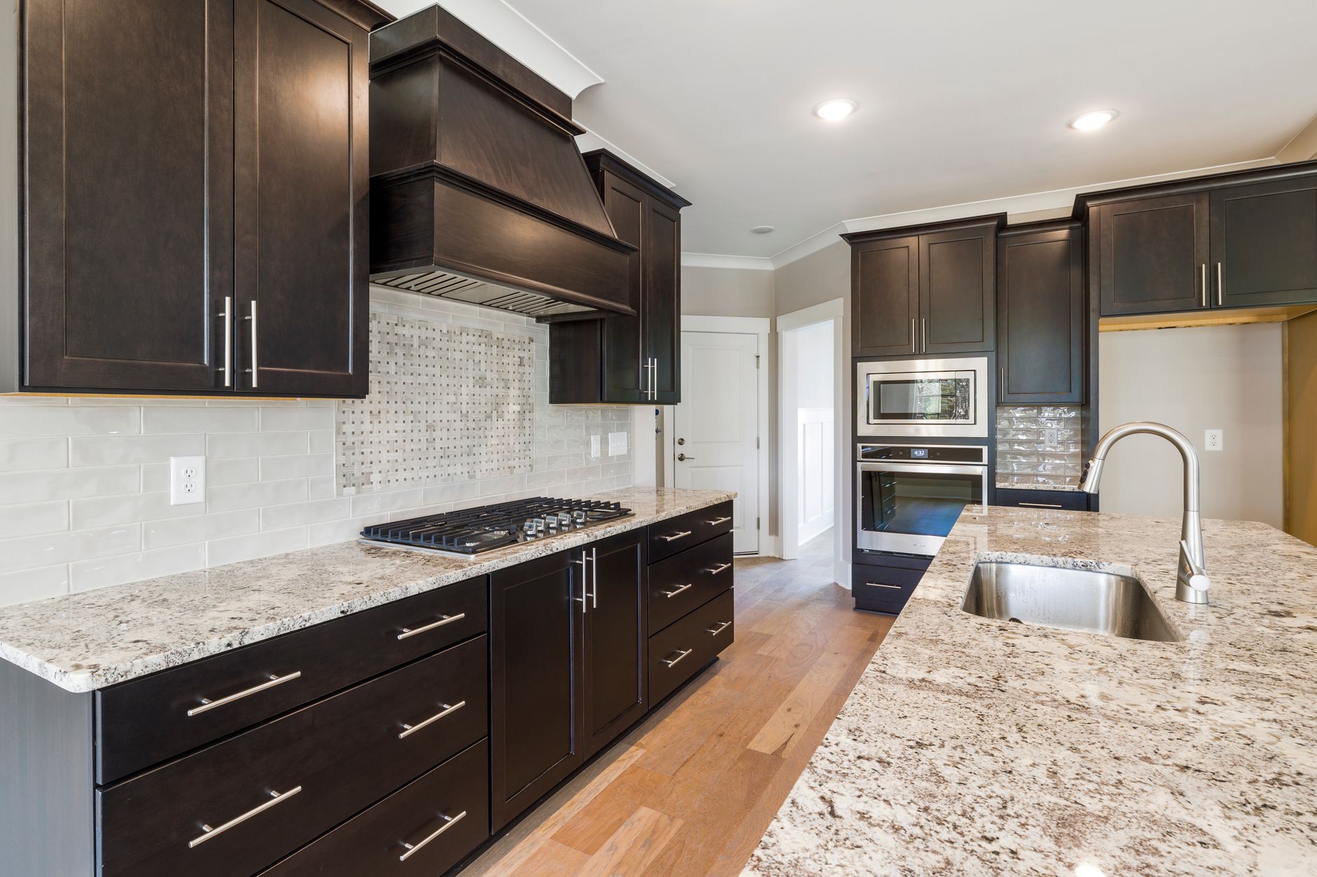 Contemporary kitchen featuring dark cabinetry, granite countertops, and stainless steel appliances in Austin, TX