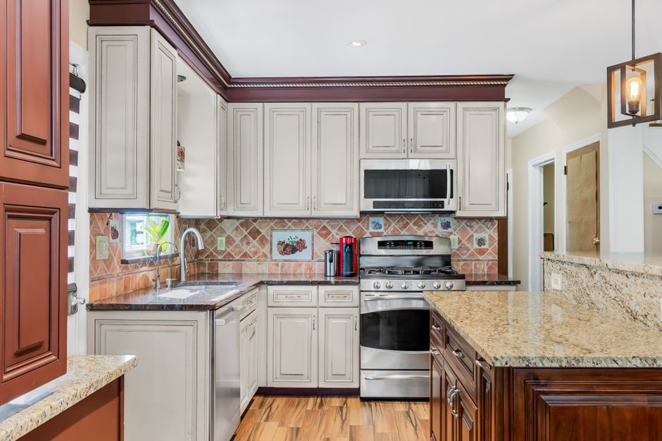 Spacious kitchen with beige cabinetry, granite countertops and stainless steel appliances.